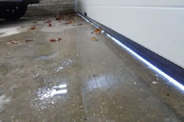 water leaking into garage under wall